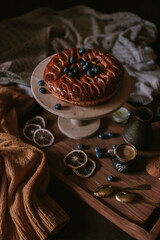 Still life of apple pie, berries, coffee and lemons on wooden tray