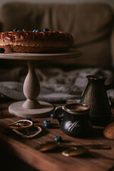 Still life of apple pie, berries, coffee and lemons on wooden tray