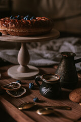 Still life of apple pie, berries, coffee and lemons on wooden tray