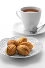 Close up view of dessert plate and cup of tea on white background