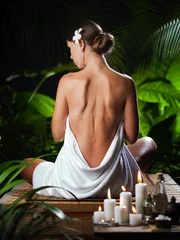 Fotobehang View of nice young woman meditating in spa tropic environment © Dmitry Ersler