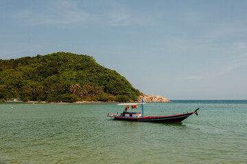 Tropical beach in Thailand with blue ocean, white sand and typical fishermen boat