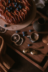 Still life of apple pie, berries, coffee and lemons on wooden tray