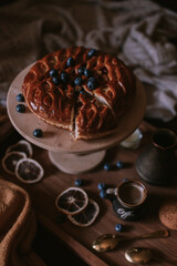Still life of apple pie, berries, coffee and lemons on wooden tray