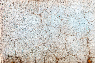 Abstract creative background of chaotic strokes of old cracked paint on concrete wall. Old surface with traces of paint, weathered, scratches and cracks for design