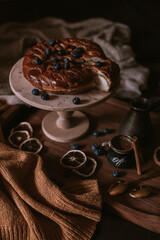 Still life of apple pie, berries, coffee and lemons on wooden tray