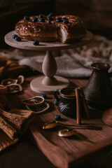 Still life of apple pie, berries, coffee and lemons on wooden tray
