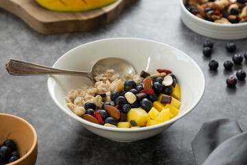 Oatmeal with dried fruits, nuts and mango. Healthy breakfast, dieting and nutrition.