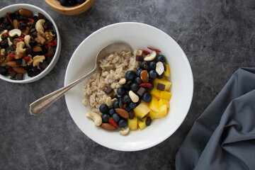 Oatmeal with dried fruits, nuts and mango. Healthy breakfast, dieting and nutrition.