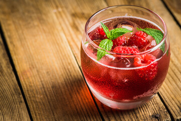 Raspberry and mint cocktail in glass on the rustic background. Selective focus. Shallow depth of field. 