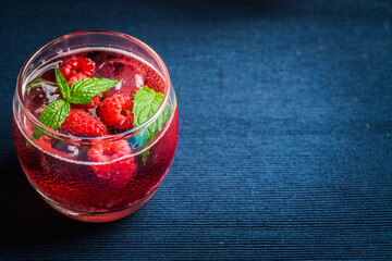 Raspberry and mint cocktail in glass on the rustic background. Selective focus. Shallow depth of field. 