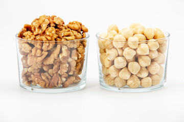Pile of walnuts pistachios and hazelnuts  in glass bowl on white background.