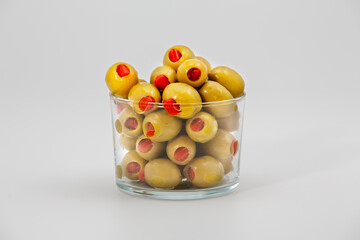 Pile of Stuffed olives in glass bowl on white background.