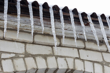 Icicles hang from the roof of the house