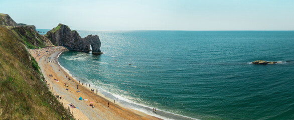 Panoramic view of Durdle Door, West Lulworth, Wareham, England. Relaxing people at Durdle Door Beach.