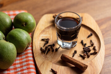 homemade nocino with green walnuts, cinnamon sticks and cloves.
