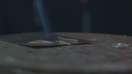 Obraz premium Jeweler makes jewelry of silver. The jeweler to melt silver, makes patterns on it, grinds, cuts and drills. work gas torch