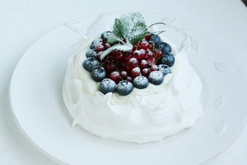 Anna Pavlova dessert with blueberries and red currants