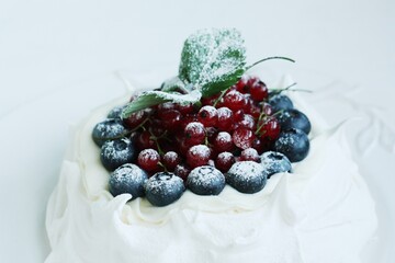 Anna Pavlova dessert with blueberries and red currants