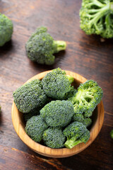 Fresh broccoli with in bowl on wooden table close up.