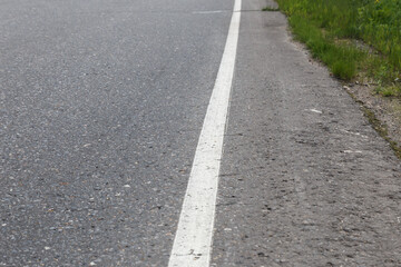 White solid line. Road marking on an asphalt road. selective focus