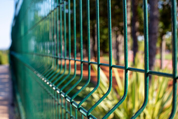 Mesh fence. Green metal fence made of welded mesh. Close up