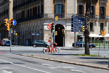 Barcelona, Spain, August 8, 2020: Woman in a bike wearing protective medical masks for prevent...