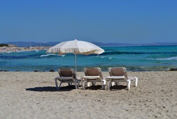 Tres sillas aprovechan para charlar mientras sus dueños se dan un baño en el mar