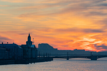 Saint Petersburg. Russia. White night. Vasilievsky island. A city under an orange sky. View from the Neva river to Vasilievsky island. Palace bridge. Bridges Of St. Petersburg. Rivers Of Petersburg.