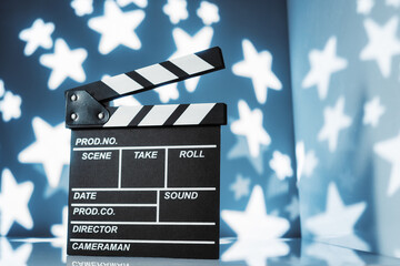 Movie clapperboard on blue starry background