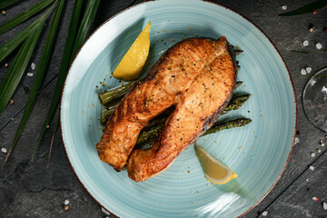 Grilled salmon and asparagus on plate with glass of white wine