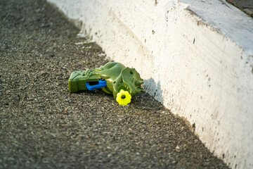 Children's plastic gun for starting soap bubbles lies on the asphalt next to the concrete kerb
