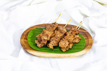 Grilled pork skewer on wood plate