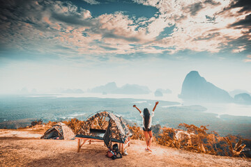 Fototapeta premium View from inside a tent on the female tourist have a rest in his camping in the mountains at sunrise. Active lifestyle and Travel destination concept.