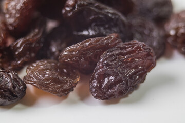 Black dried raisins on a white background