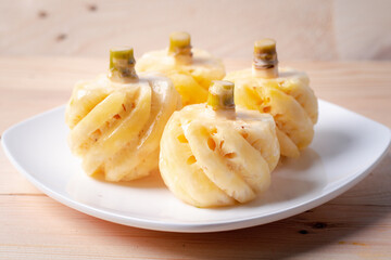 Phulae pineapple on a plate on a wooden background