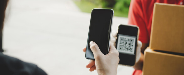 Panoramic banner. hand using digital mobile phone scan QR code paying for receive parcel post box from delivery service man at door home, delivery, digital payment technology, online shopping concept