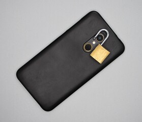 Mobile with open padlock around the photo camera, computer insecurity concept.