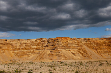 Landscape. Sandy mountains. A dark thundercloud is approaching.
