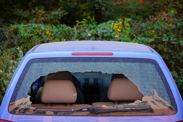 Broken car rear window. Busted back window of car. Rear windscreen of car smashed up, car back...