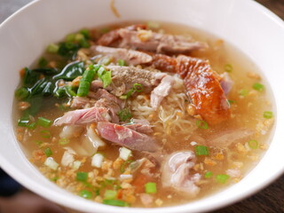 Close up of roasted duck over egg noodles soup ready to be served