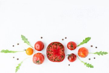assortment of bright, ripe, multi-colored tomatoes, on a white worn background. the view from the top. concept of the harvest season