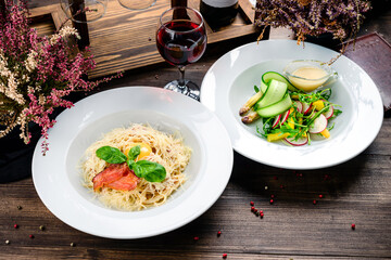 two course lunch - pasta with bacon and cheese and fresh salad with radishes and herbs