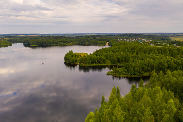 Fototapeta na wymiar panoramic landscape of lake and forest around in summer at dawn filmed from a drone