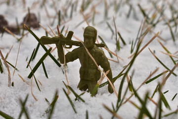 A Toy Soldier Resting His Rifle on His Shoulder in a Patch of Snow