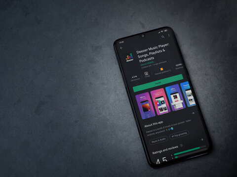 Lod, Israel - July 8, 2020: Deezer Music Player app play store page on the display of a black mobile smartphone on dark marble stone background. Top view flat lay with copy space.