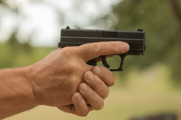 White man's hands holding a handgun