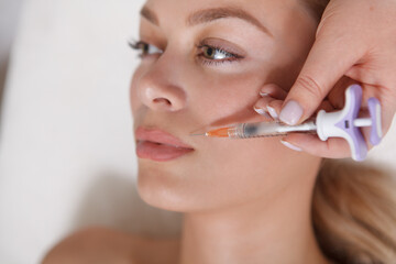 Cropped close up of a young woman getting facial injections at cosmetology clinic