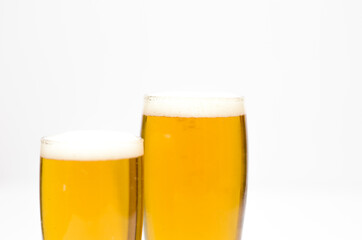 Two glasses full of beer with foam along on a white background.
