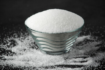 A glass bowl with white sugar